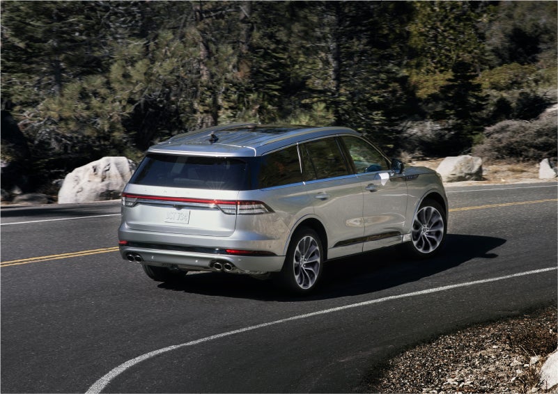 A 2023 Lincoln Aviator® Grand Touring model is shown being driven on a tight turn of a mountain road | Napleton River Oaks Lincoln in Calumet City IL