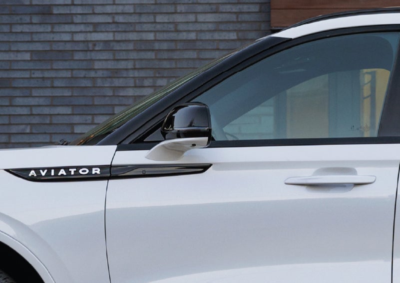 The driver’s side door and fender badging of a white 2026 Lincoln Aviator® SUV are showcased. | Napleton River Oaks Lincoln in Calumet City IL