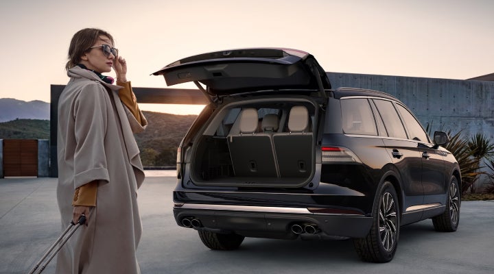 A woman approaches a 2026 Lincoln Aviator® SUV with its rear liftgate open. | Napleton River Oaks Lincoln in Calumet City IL