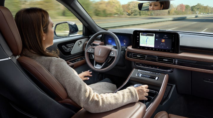A 2026 Lincoln Aviator® SUV is being driven hands-free on a highway near a forest | Napleton River Oaks Lincoln in Calumet City IL
