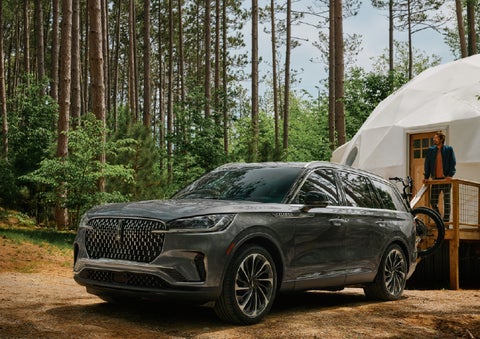 A 2027 Lincoln Aviator® is parked next to a high end glamping site. | Napleton River Oaks Lincoln in Calumet City IL