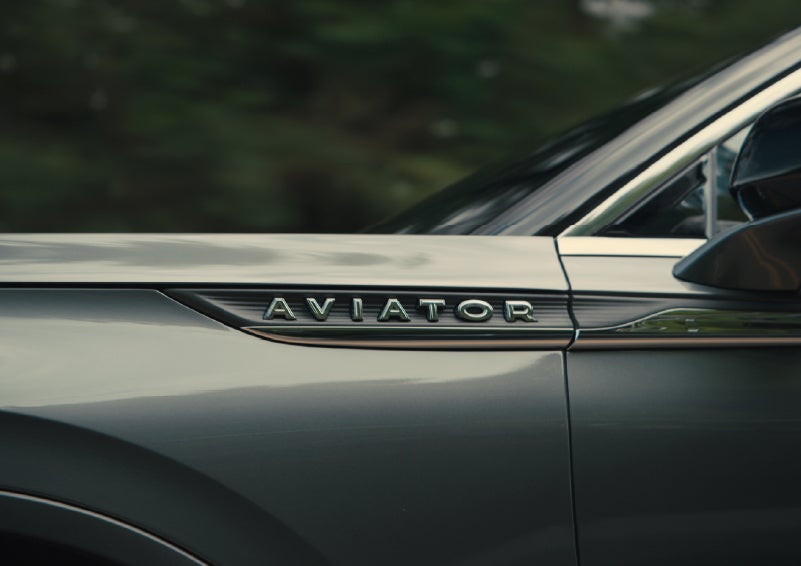 The driver’s side door and fender badging of a gray 2027 Lincoln Aviator® SUV are showcased. | Napleton River Oaks Lincoln in Calumet City IL